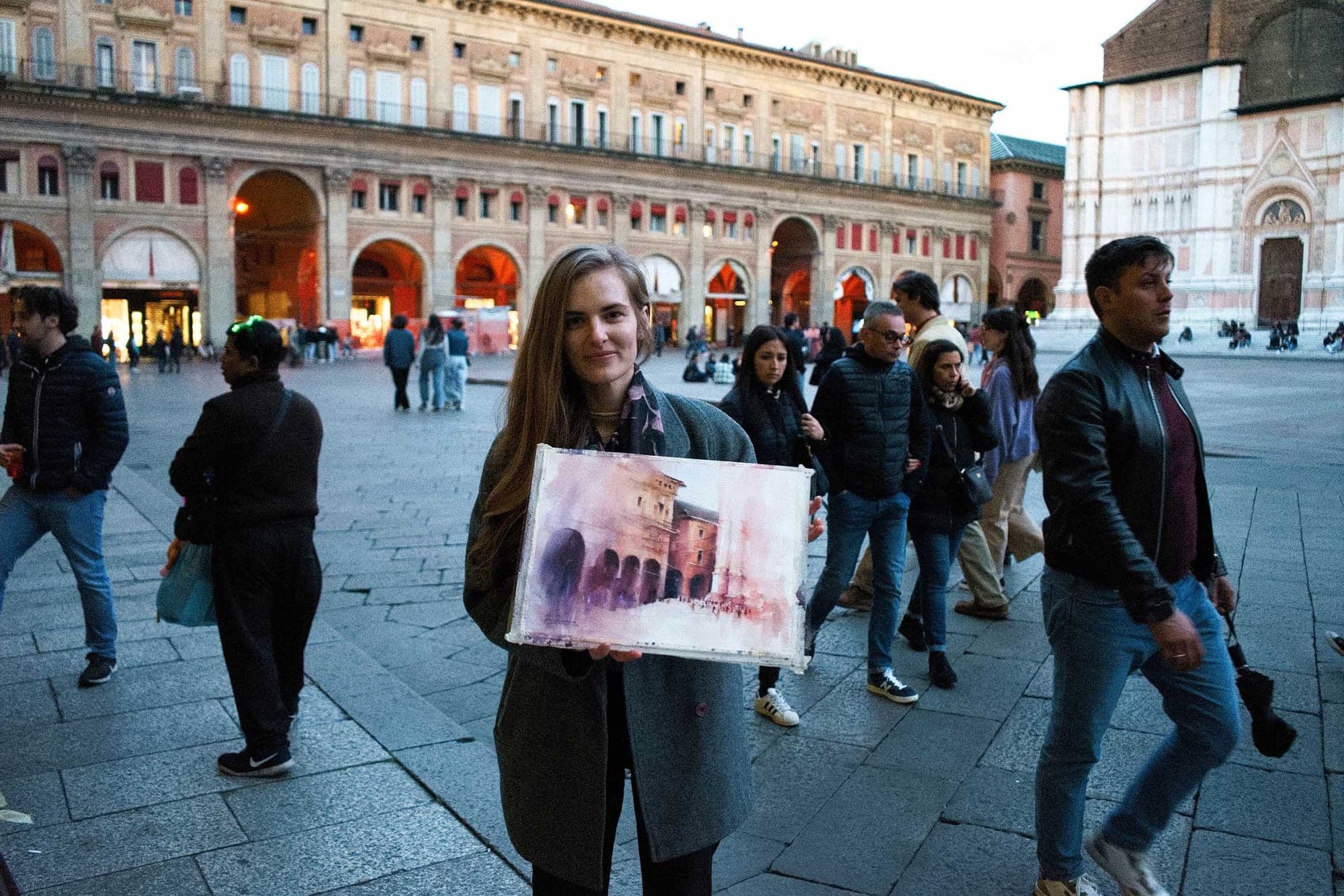 Kasia hält ihr Aquarell der Piazza Maggiore in Bologna